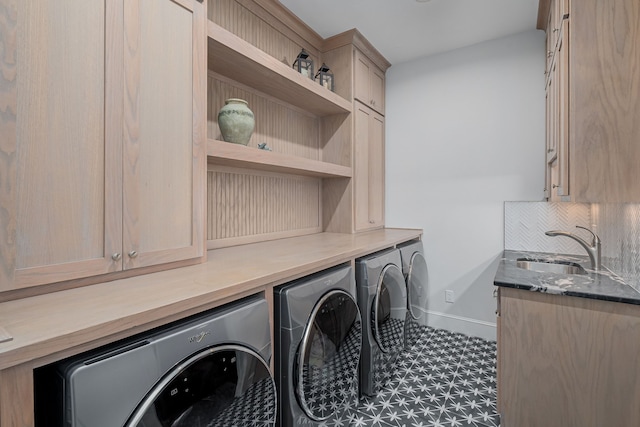 laundry room with cabinets, separate washer and dryer, and sink