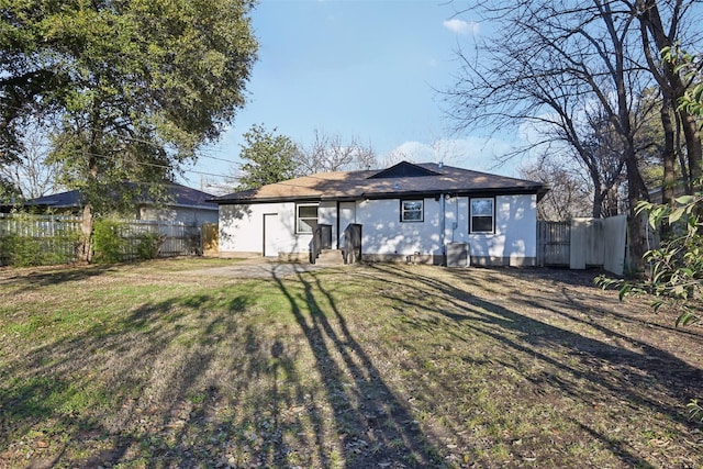 rear view of property featuring a lawn