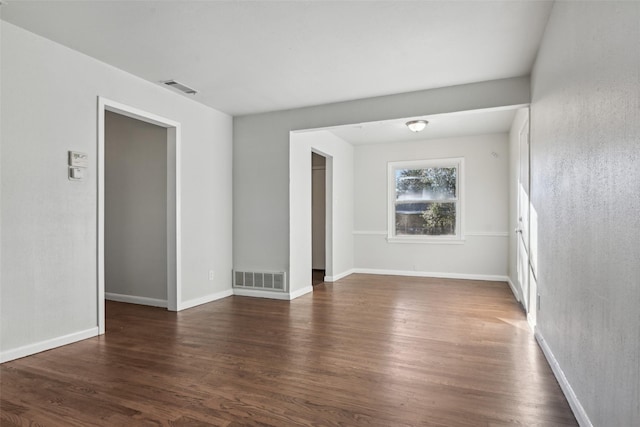 unfurnished room with dark hardwood / wood-style flooring