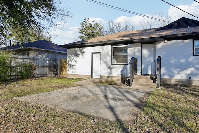 rear view of property with a yard and a patio area