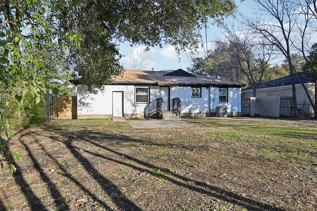 rear view of house featuring a yard