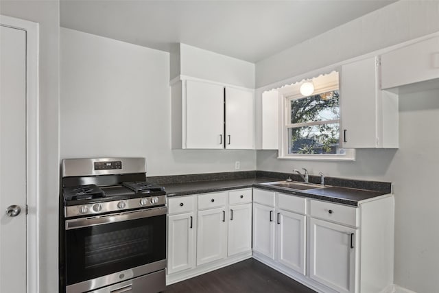 kitchen with sink, stainless steel range with gas cooktop, dark hardwood / wood-style floors, and white cabinets