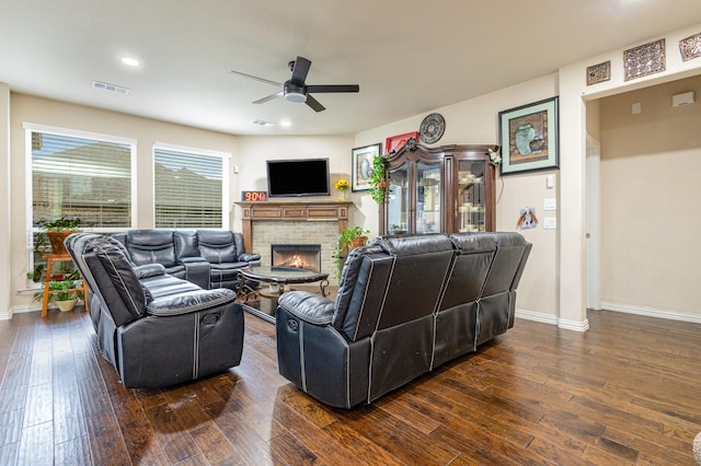 living room with ceiling fan, dark hardwood / wood-style floors, and a brick fireplace