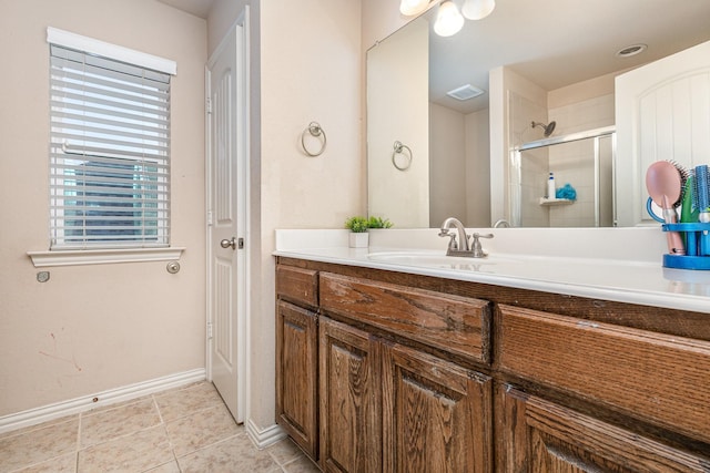 bathroom with tile patterned flooring, vanity, and a shower with shower door