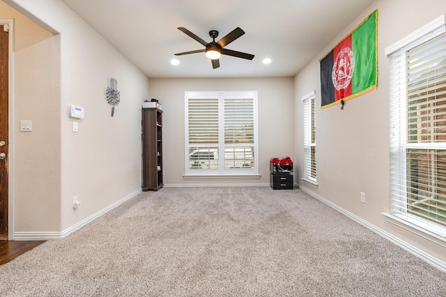 carpeted spare room featuring ceiling fan