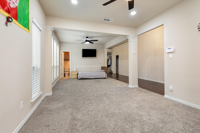 unfurnished bedroom featuring decorative columns, carpet, and ceiling fan