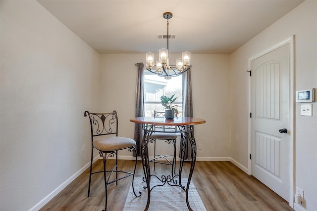 dining room featuring hardwood / wood-style floors and a notable chandelier