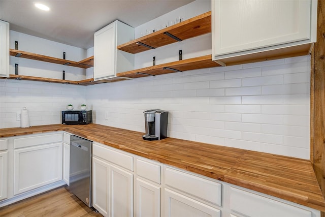 kitchen with butcher block countertops, light hardwood / wood-style flooring, stainless steel dishwasher, white cabinets, and backsplash