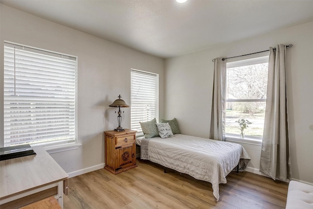 bedroom featuring multiple windows and light wood-type flooring