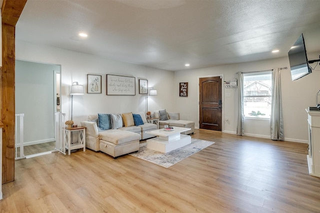 living room with a textured ceiling and light hardwood / wood-style floors