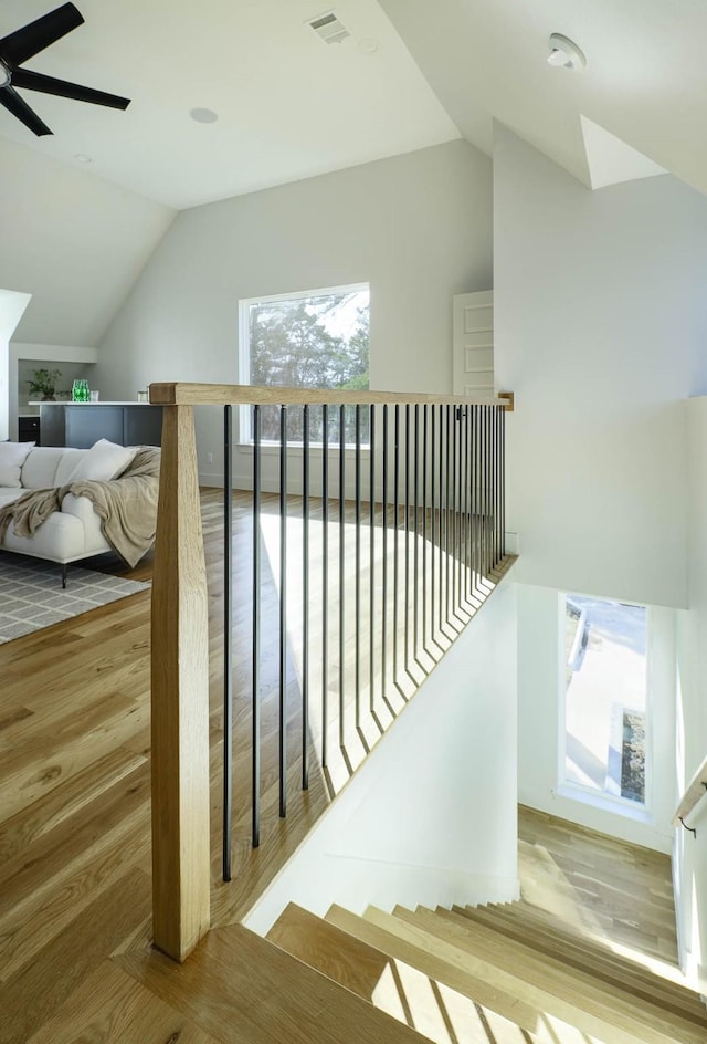 stairs with lofted ceiling, hardwood / wood-style floors, and ceiling fan