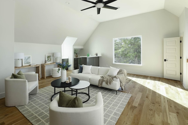 living room featuring ceiling fan, vaulted ceiling, and light hardwood / wood-style flooring