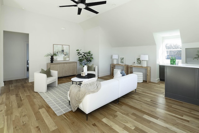 living room featuring ceiling fan, lofted ceiling, and light wood-type flooring