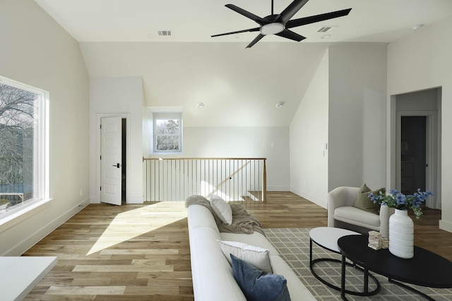 living room featuring ceiling fan, lofted ceiling, and light hardwood / wood-style flooring