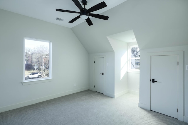 bonus room with light carpet, a wealth of natural light, lofted ceiling, and ceiling fan