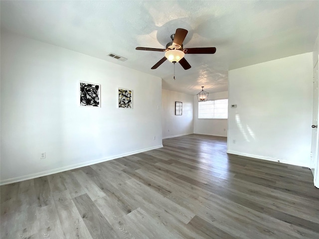 unfurnished room with wood-type flooring, ceiling fan with notable chandelier, and a textured ceiling