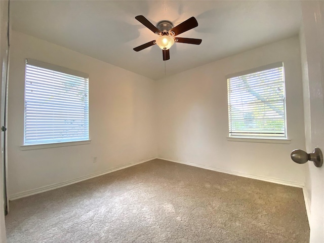 carpeted spare room with ceiling fan