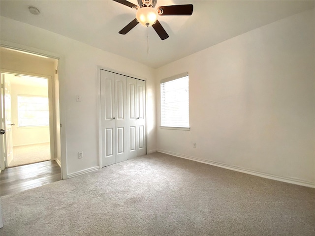 unfurnished bedroom with light carpet, a closet, and ceiling fan