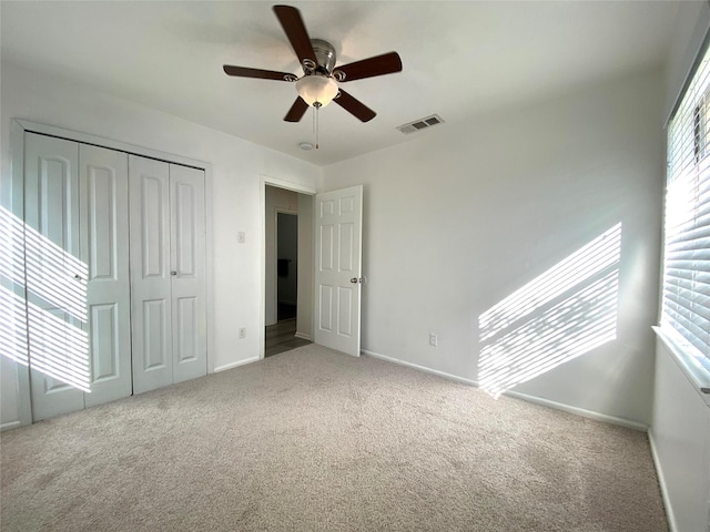 unfurnished bedroom with carpet floors, ceiling fan, and a closet