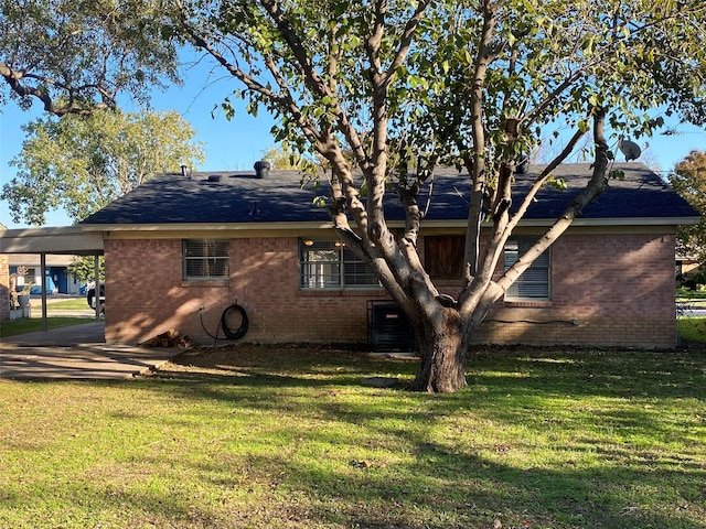 back of house featuring a carport and a yard