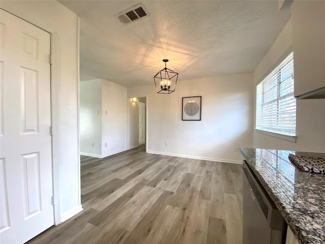 unfurnished dining area featuring hardwood / wood-style floors and an inviting chandelier