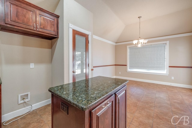 kitchen featuring dark stone countertops, a notable chandelier, a kitchen island, decorative light fixtures, and vaulted ceiling