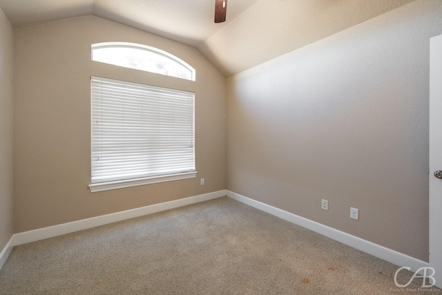 carpeted empty room featuring ceiling fan and lofted ceiling