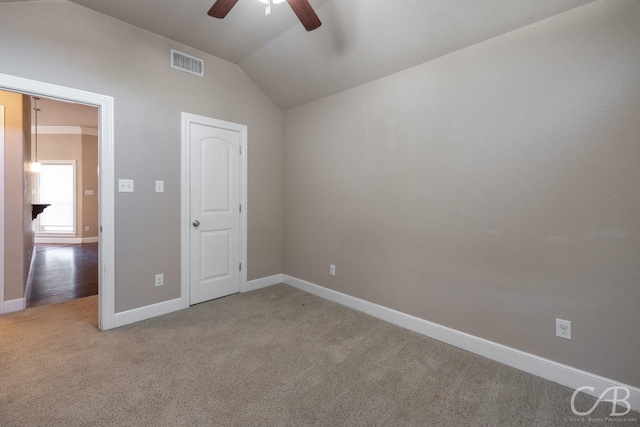 unfurnished bedroom featuring vaulted ceiling, light colored carpet, and ceiling fan