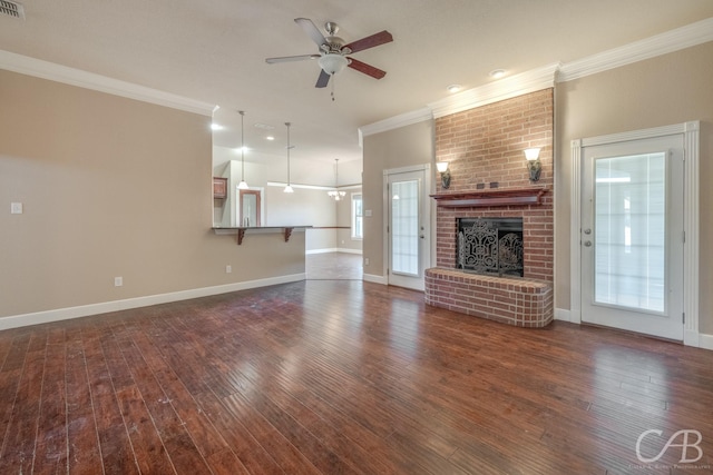 unfurnished living room featuring dark hardwood / wood-style flooring, a brick fireplace, ornamental molding, and ceiling fan