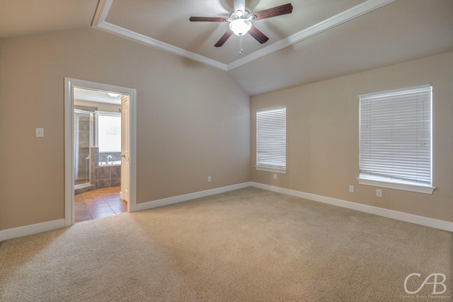 empty room featuring ceiling fan, light colored carpet, crown molding, and vaulted ceiling