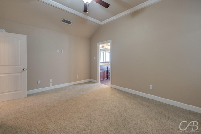 carpeted spare room featuring vaulted ceiling, ornamental molding, and ceiling fan