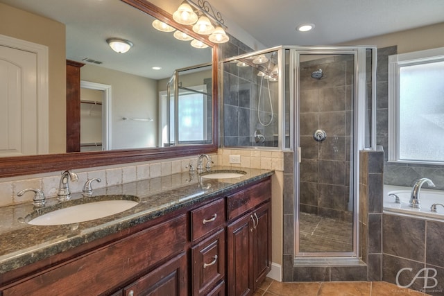 bathroom featuring tile patterned flooring, shower with separate bathtub, and vanity