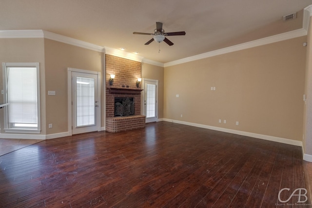 unfurnished living room with dark hardwood / wood-style flooring, a brick fireplace, and crown molding