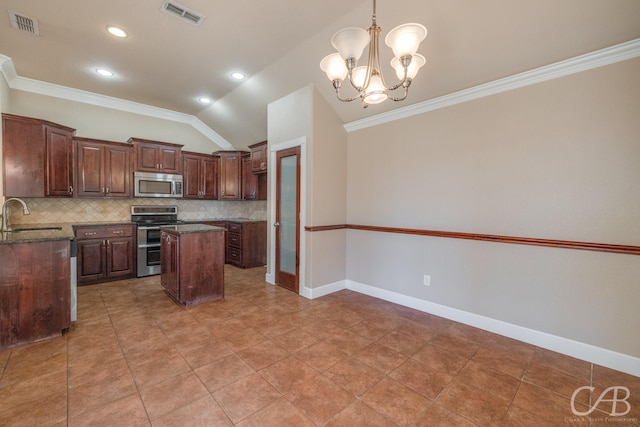 kitchen with pendant lighting, stainless steel appliances, a kitchen island, and backsplash