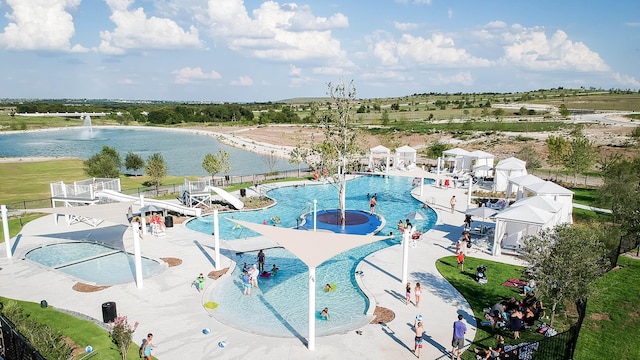 view of swimming pool featuring pool water feature and a water view