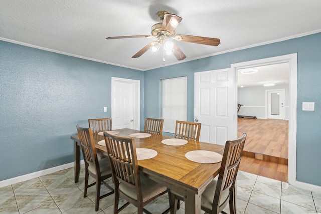 tiled dining space featuring crown molding and ceiling fan