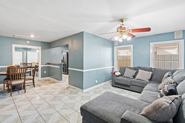 tiled living room with a healthy amount of sunlight, a textured ceiling, and ceiling fan