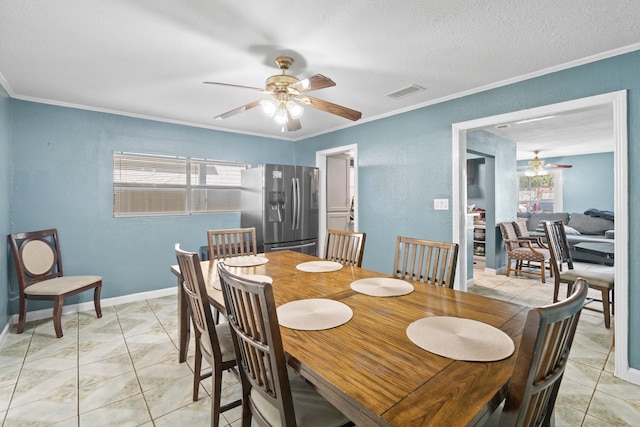 tiled dining room with ceiling fan, ornamental molding, and a textured ceiling