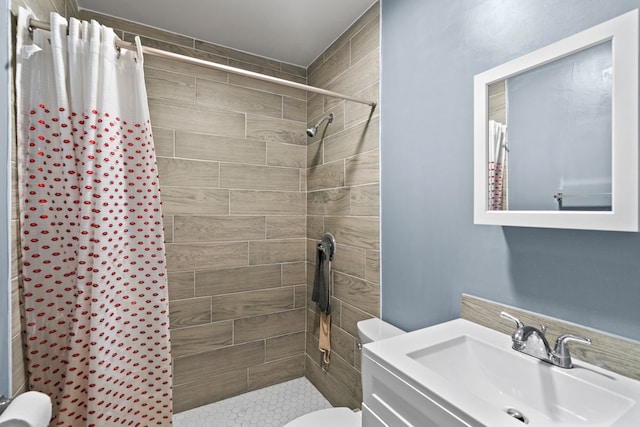 bathroom with walk in shower, vanity, and toilet