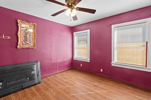 spare room with ceiling fan, hardwood / wood-style floors, and heating unit