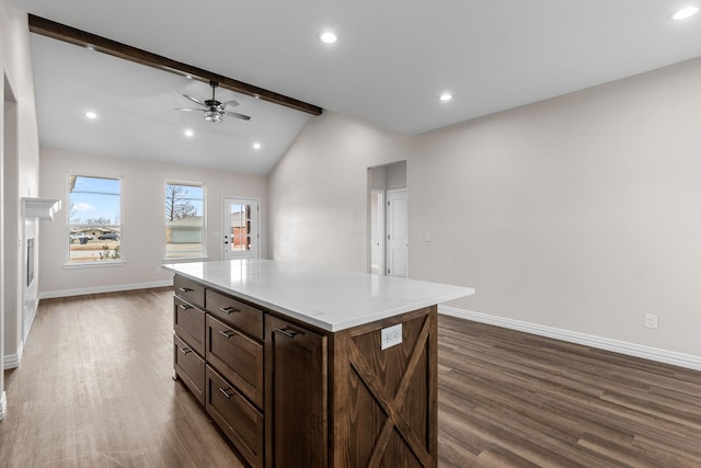 kitchen featuring lofted ceiling with beams, ceiling fan, a center island, and dark hardwood / wood-style flooring