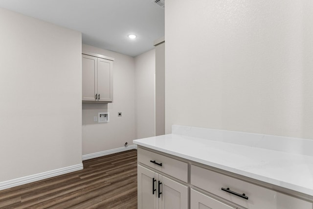 laundry area with hookup for a washing machine, dark hardwood / wood-style floors, hookup for an electric dryer, and cabinets