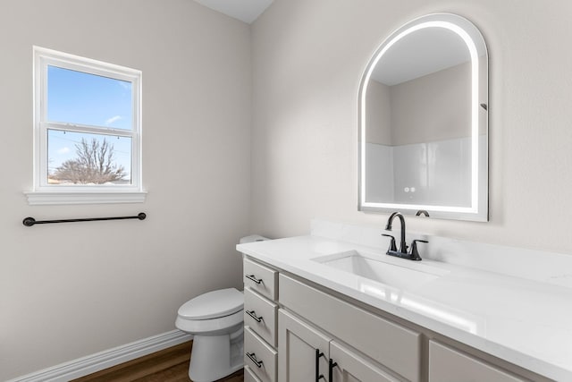 bathroom with hardwood / wood-style flooring, vanity, toilet, and a shower