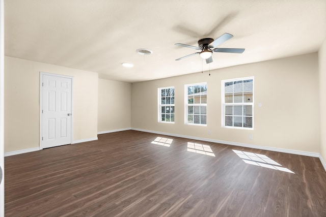 empty room with dark hardwood / wood-style flooring and ceiling fan