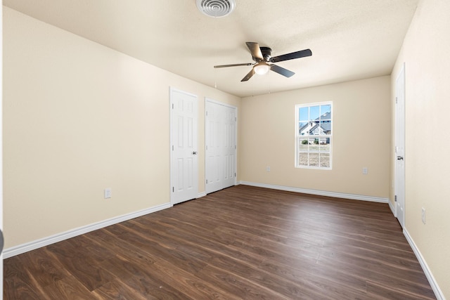 unfurnished bedroom with dark wood-type flooring, ceiling fan, and a textured ceiling