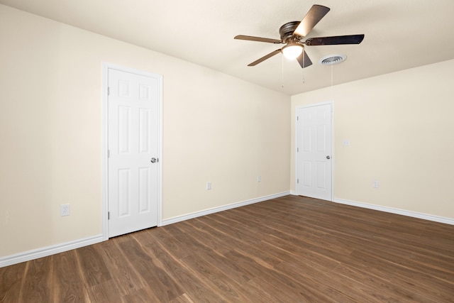 spare room featuring dark wood-type flooring and ceiling fan