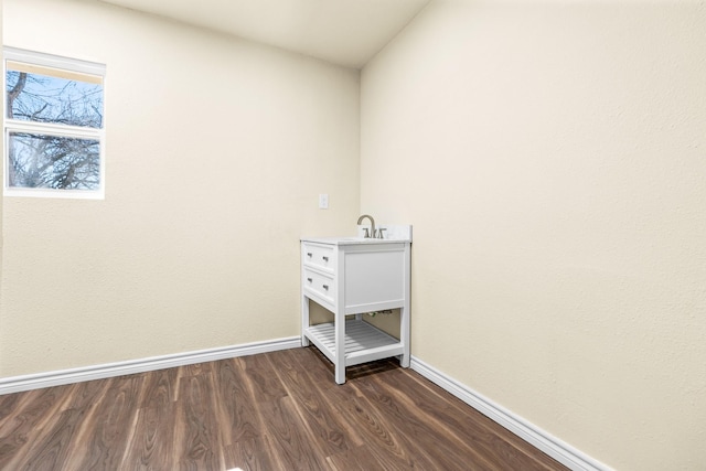 laundry room featuring sink and dark hardwood / wood-style floors