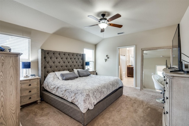 carpeted bedroom with ceiling fan, vaulted ceiling, and ensuite bath