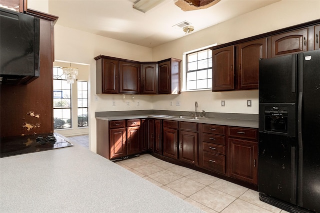 kitchen featuring sink, light tile patterned floors, a wealth of natural light, and black appliances