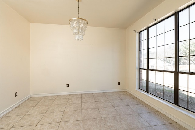 spare room with light tile patterned floors and a chandelier